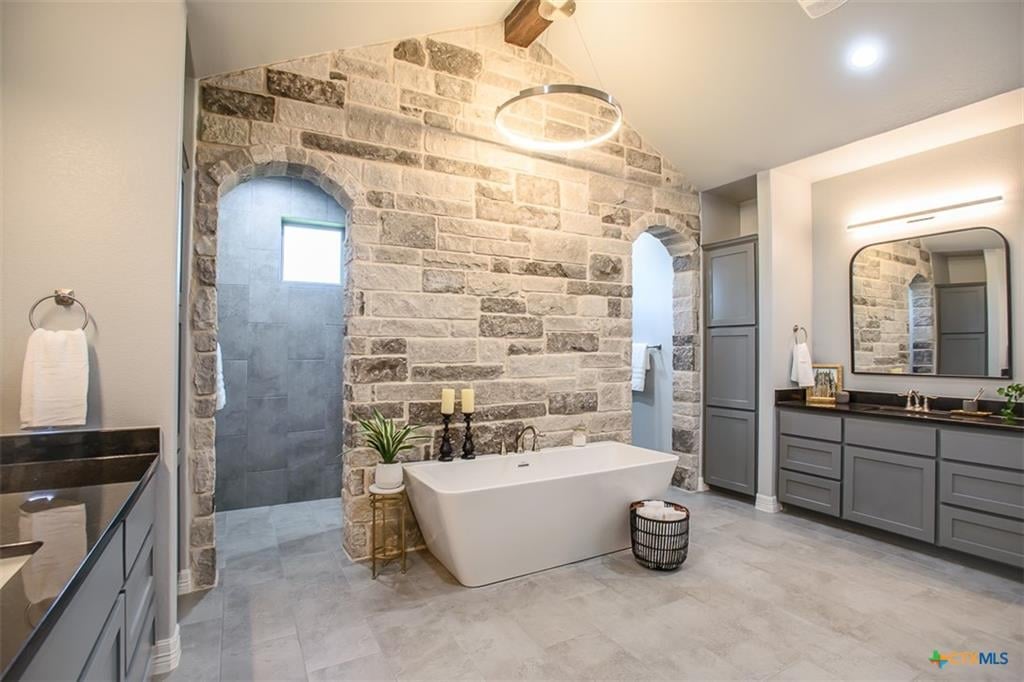 Builder-upgraded primary bathroom with tile surround in Hartrick Ranch