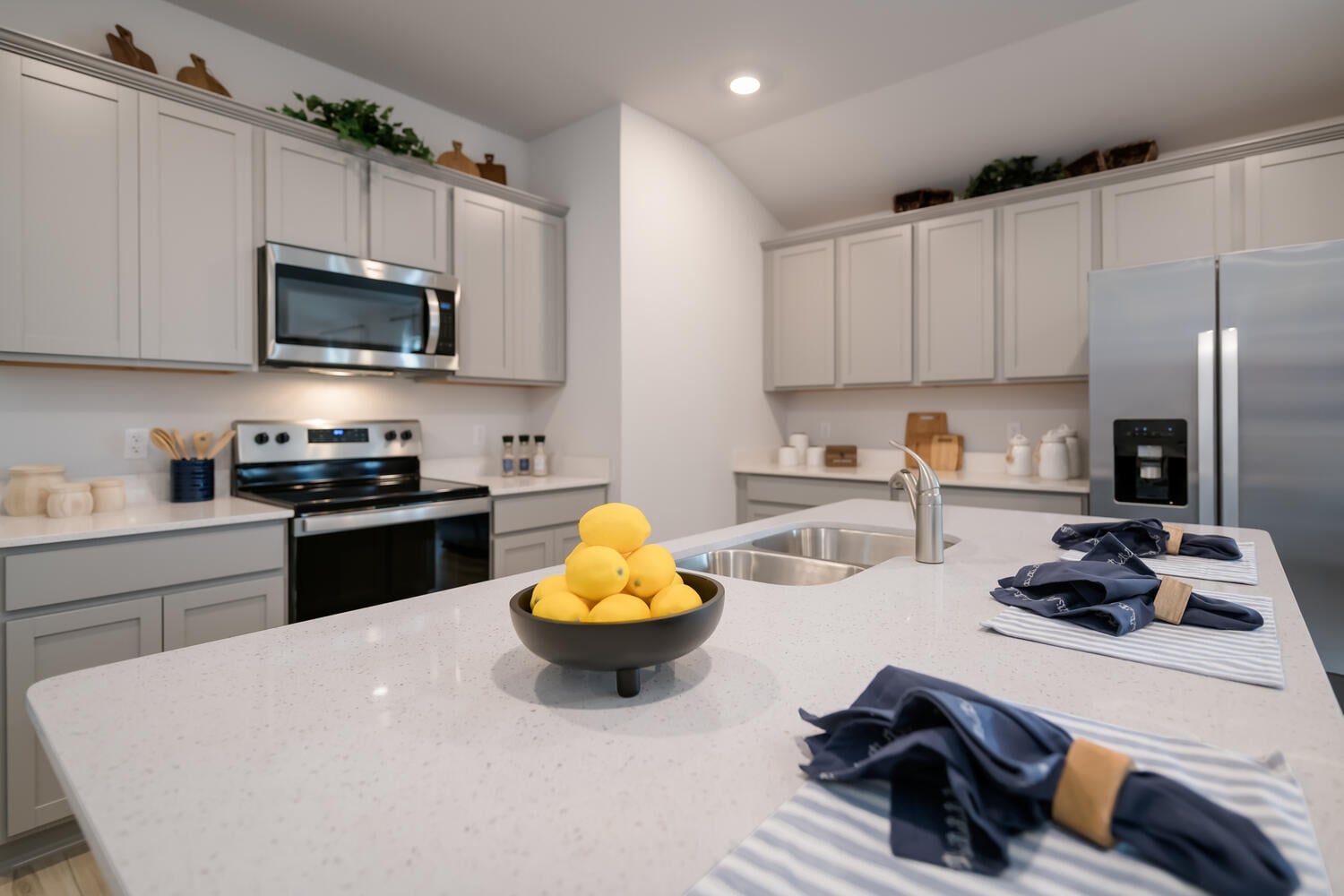 Standard D.R. Horton kitchen finish level in a Temple TX Express Series home — granite counters, stainless appliances, vinyl plank flooring