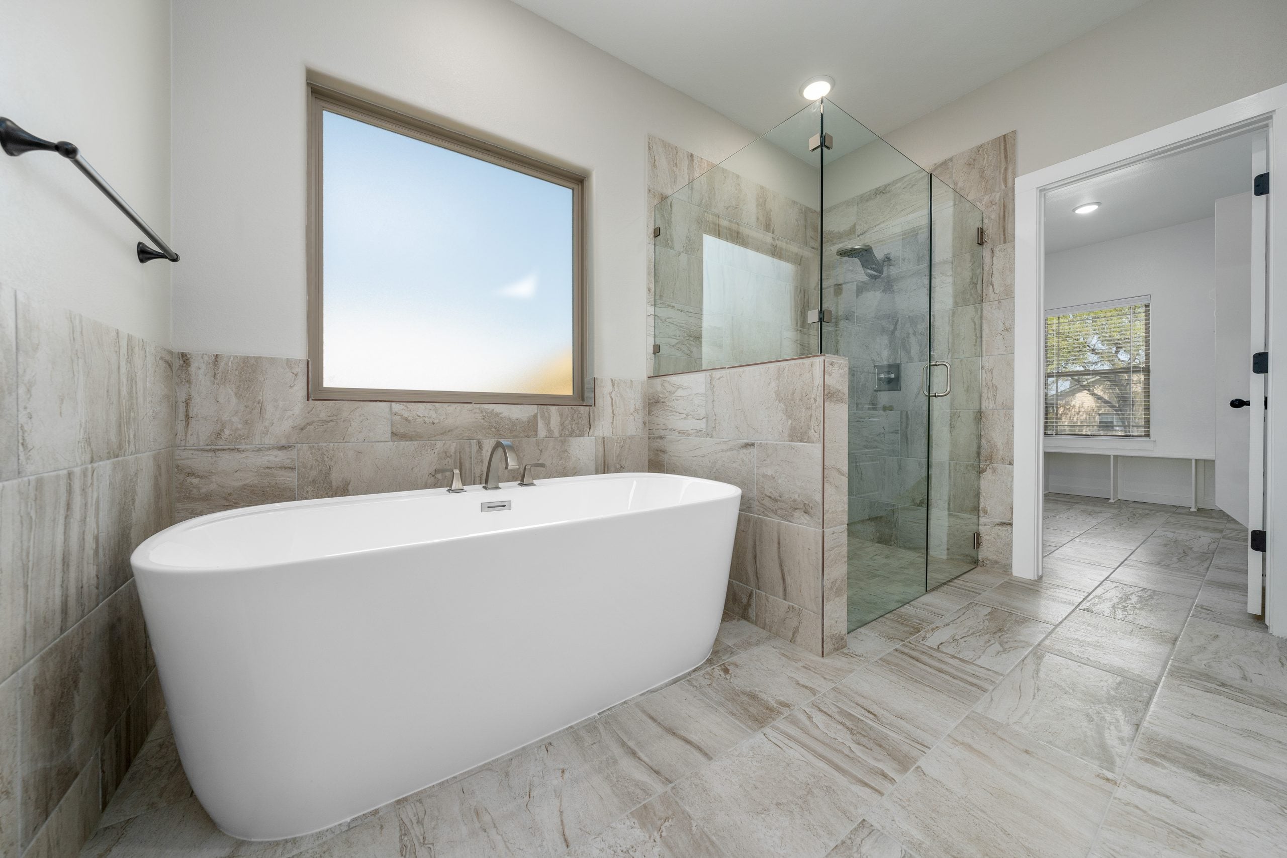 Kiella primary bathroom with garden tub and glass-enclosed shower