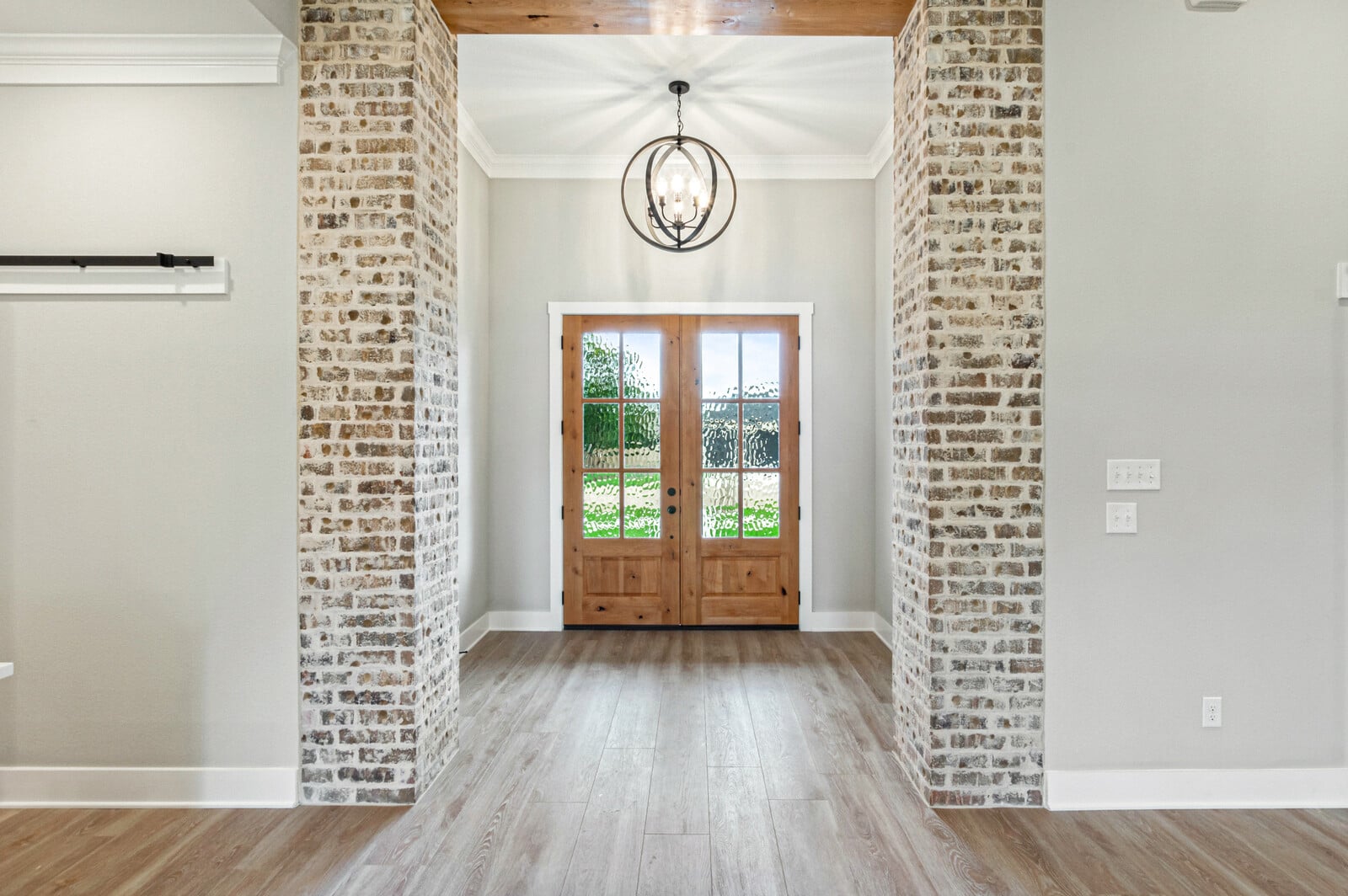 Kiella home entryway with crown molding and upgraded flooring