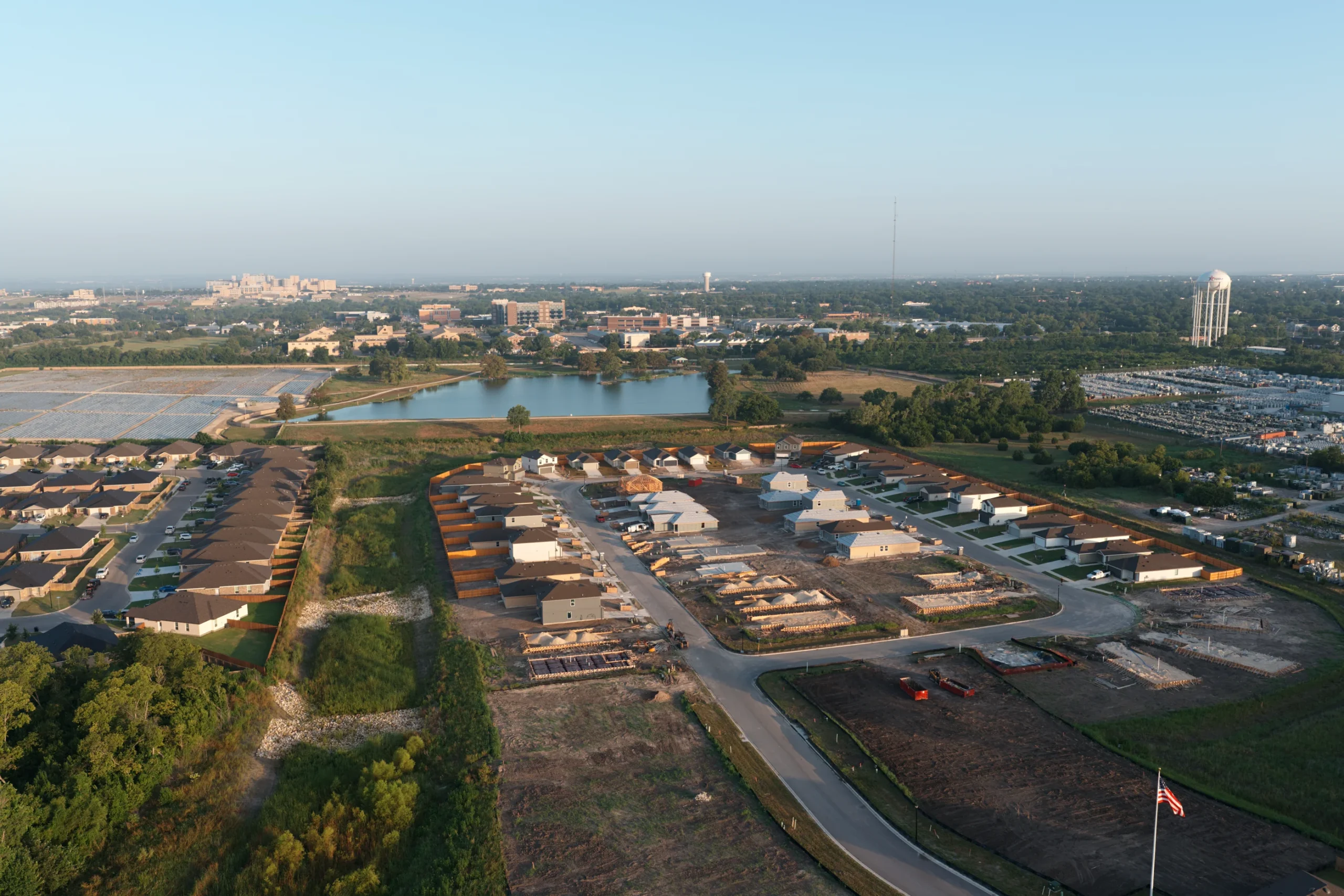 Angled aerial view across the pond toward Pecan Creek homes