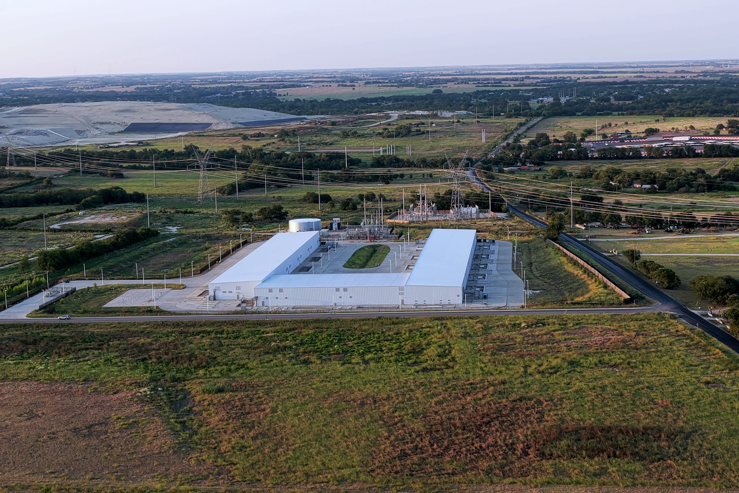 Aerial view of a data center building, an electrical substation and transmission lines near Bob White Road, Temple, TX