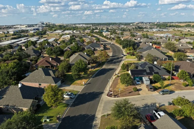Aerial view of a curving residential street and homes in Canyon Ridge, Temple TX