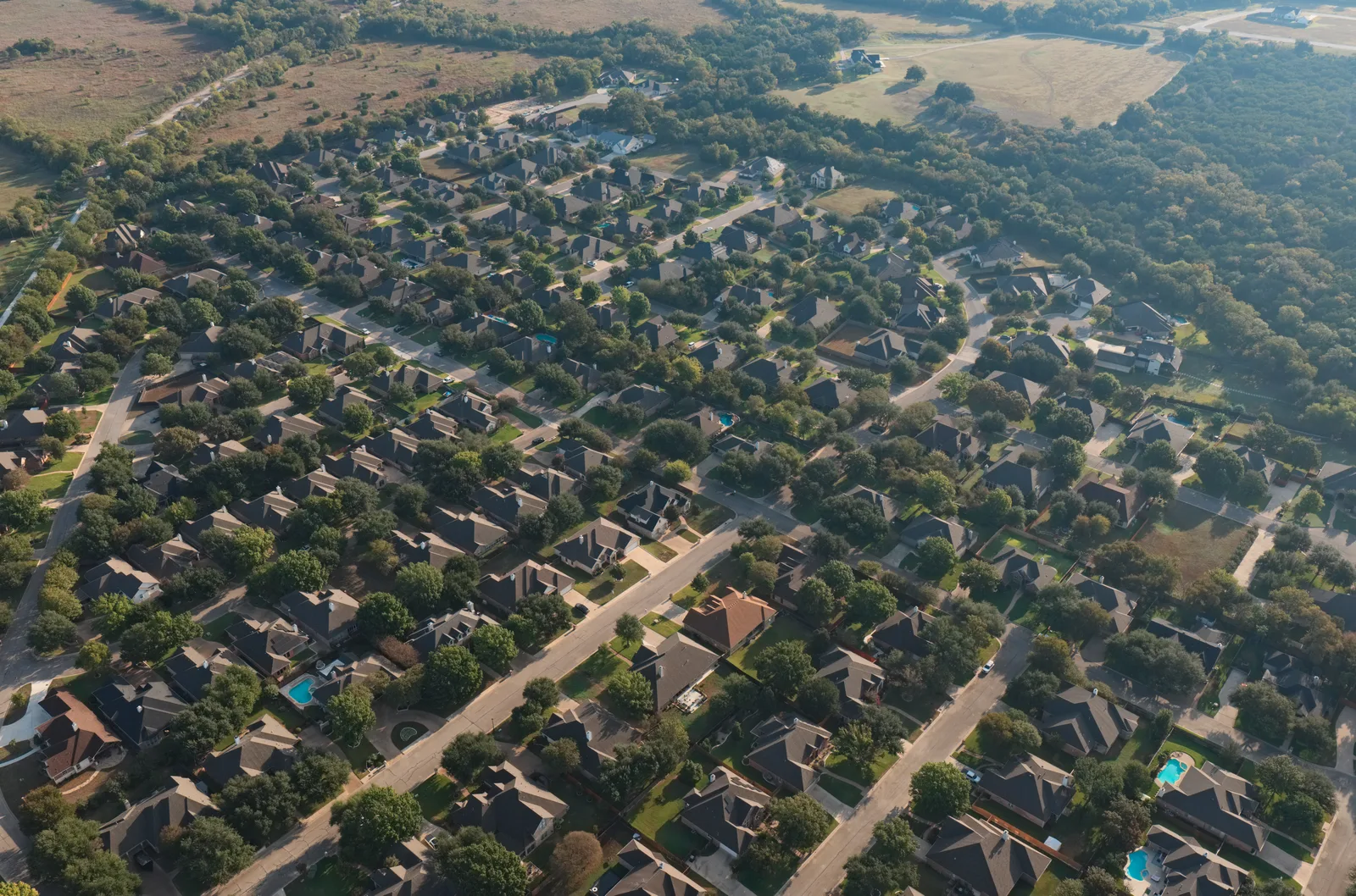 Homes, streets, trees and open land in the Deerfield neighborhood, photographed from the air.