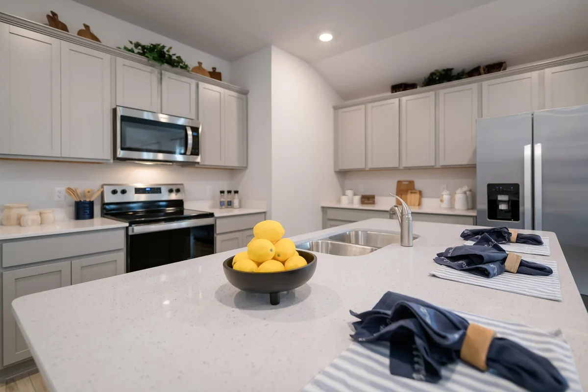 Standard D.R. Horton kitchen finish level in a Temple TX Express Series home — granite counters, stainless appliances, vinyl plank flooring
